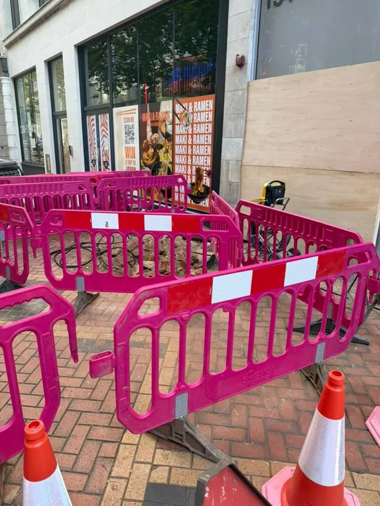 Excavation behind safety barriers on a shop front