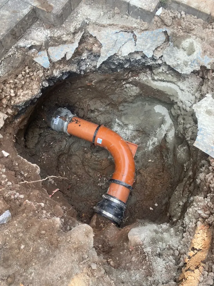 Excavated broken drain with new bend fitted