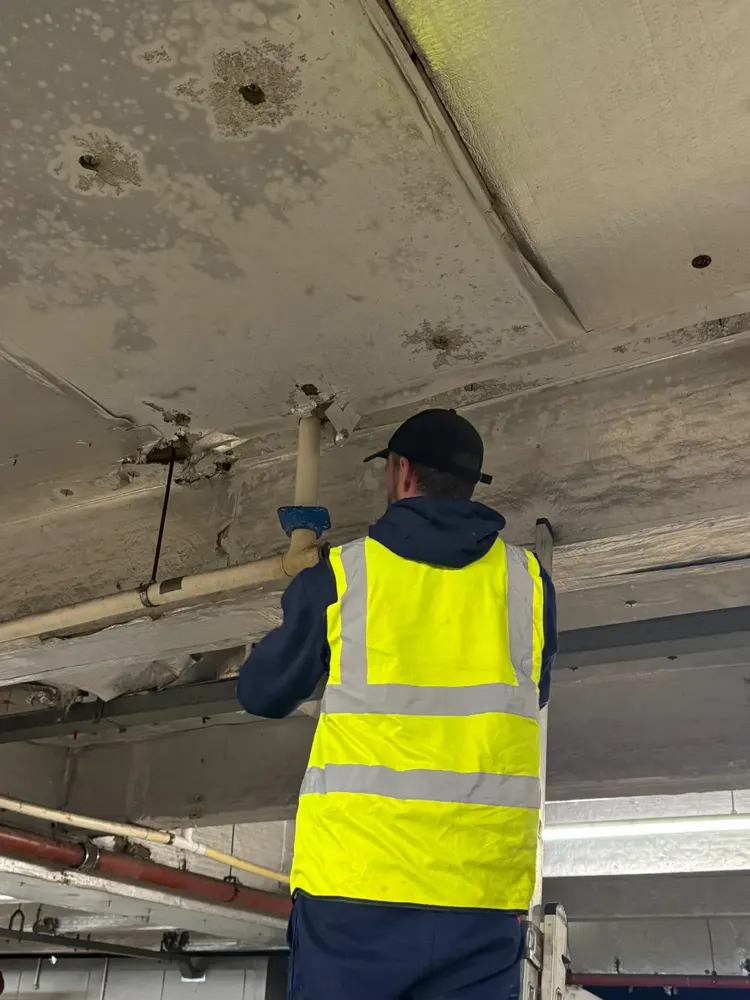 Engineer in hi-vis relining a drain pipe