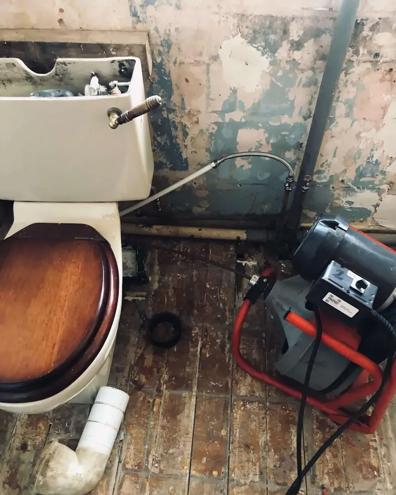 Toilet being unblocked with drain machine